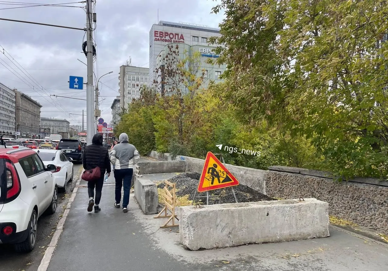 Провал на Красном проспекте, на участке 182, образовался этим летом. Дорогу заливает ливнем, откос тротуара размывает. На участке введён режим повышенной готовности, яму огородили бетонными блоками.